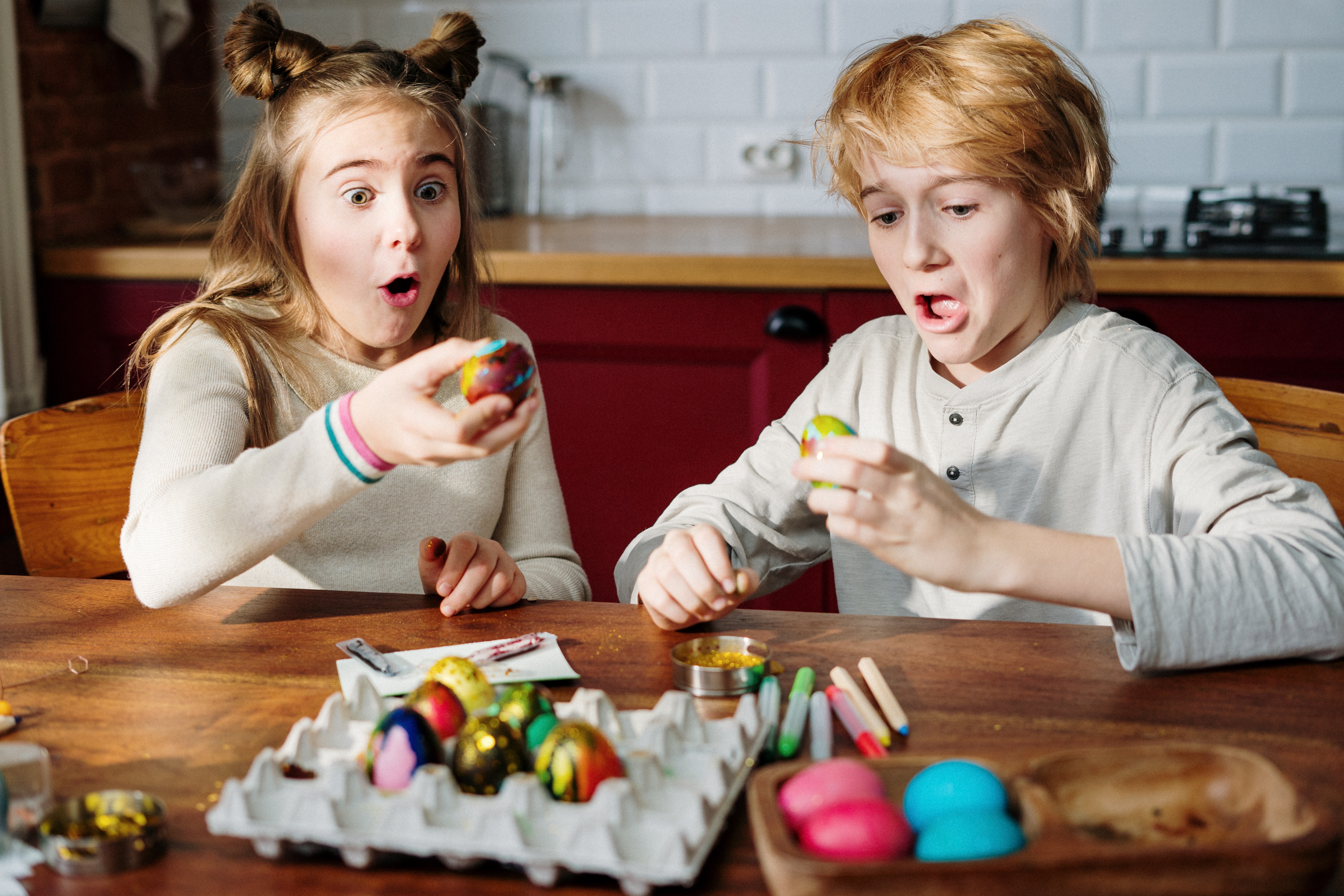 Two children making easter eggs. 