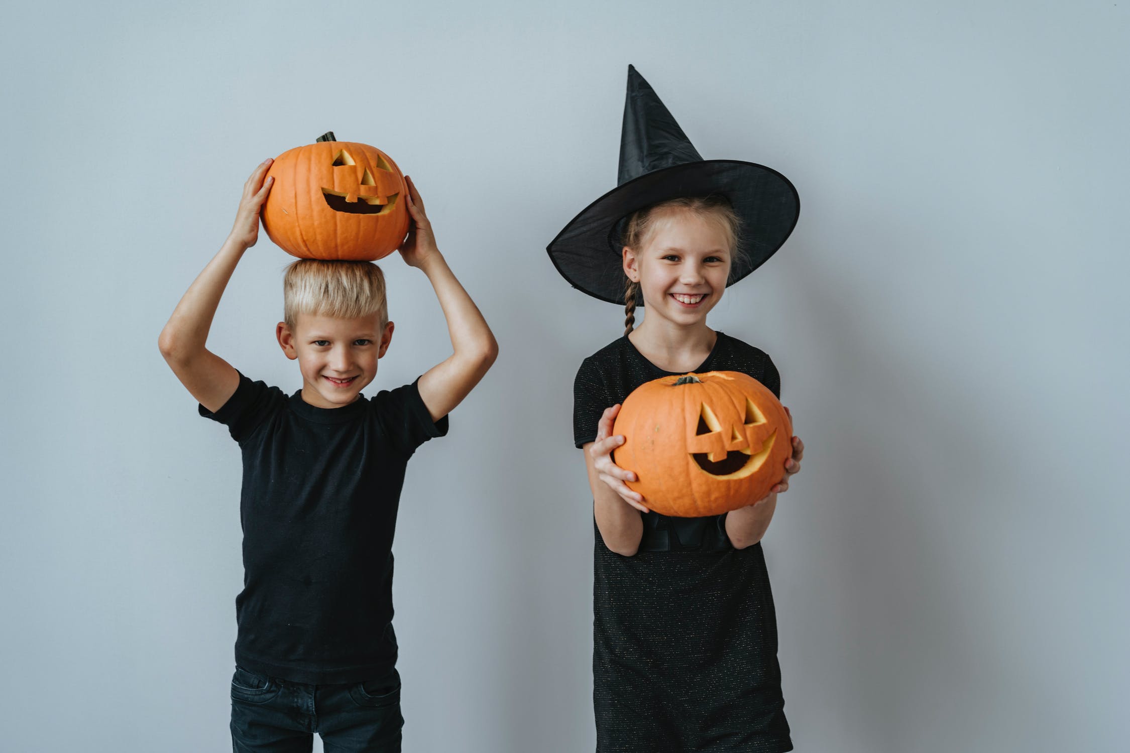 Two children holding jack o' lanterns 