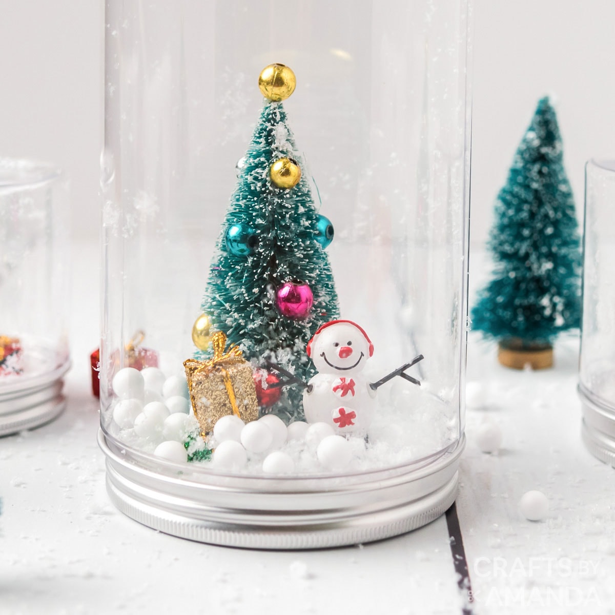 waterless snowglobe with a tree, presents and a snowman inside