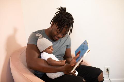 Father reading to infant child.