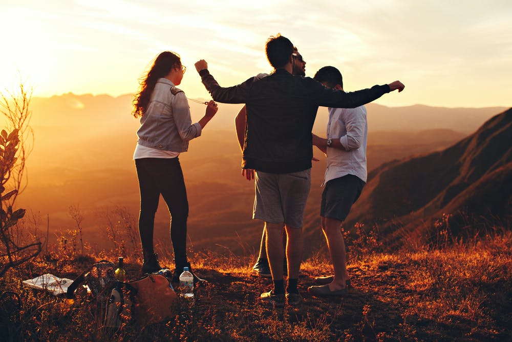 four teenage friends standing on a hill 