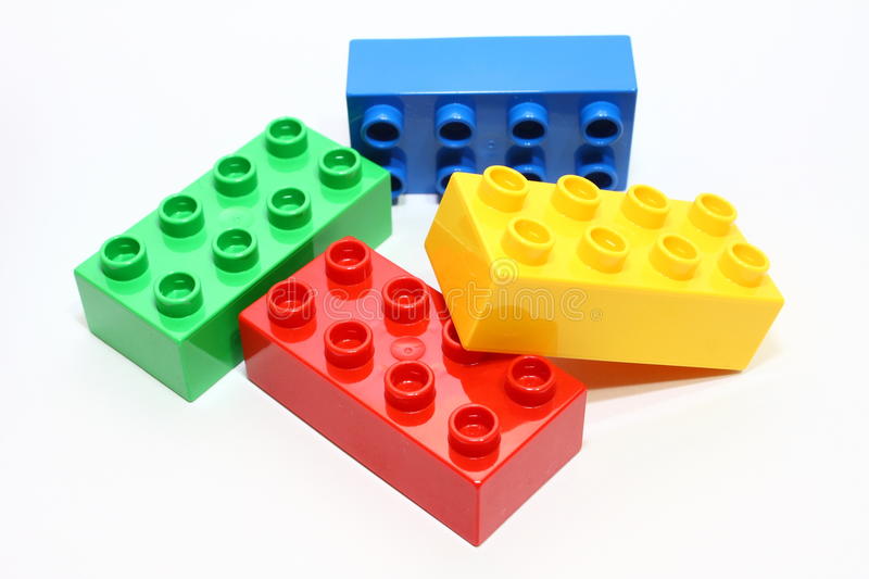 Green, blue, yellow, and red Lego bricks in a pile.