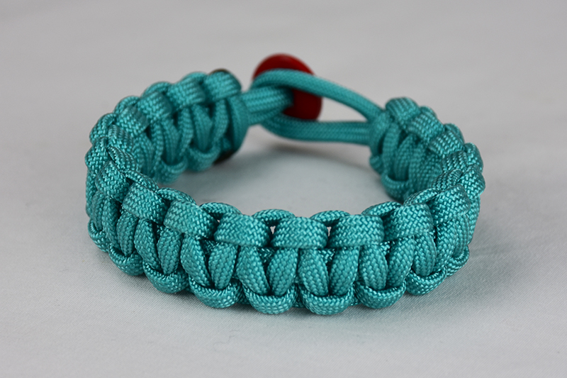 Teal woven paracord bracelet closed with red button