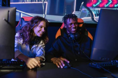 a boy and a girl playing games on a computer.