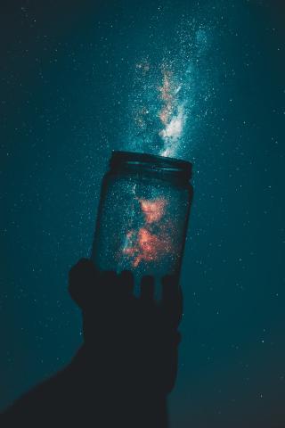 jar with a galaxy of stars coming out of it 
