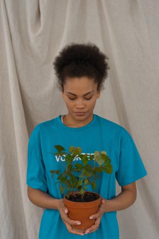 Young woman holding a potted plant 