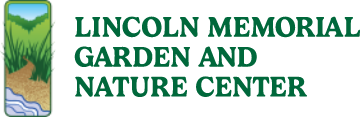 A patch of water, soil, and grass with the words: "Lincoln Memorial Garden and Nature Center" in green text.